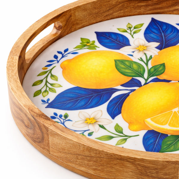 Detalle de bandeja redonda de madera de mango con asas laterales y superficie esmaltada con limones.
