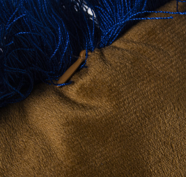 Detalle de terciopelo dorado y flecos decorativos azules