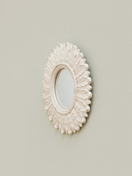 Espejo crema envejecido colgado en pared