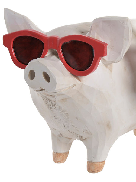 Detalle del rostro de un cerdo blanco de resina con grandes gafas de sol rojas