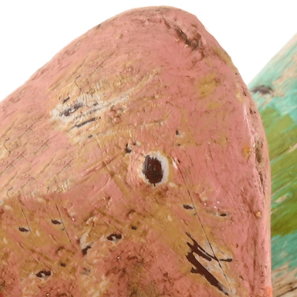 Detalle de la cabeza de un pájaro decorativo con pintura desgastada de estilo rústico.