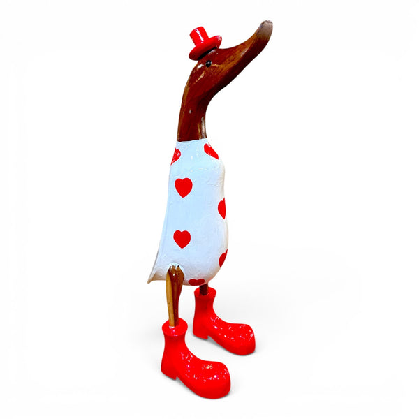 Figura artesanal de pato de madera hecha en Indonesia con decoración de corazones vista lateral.
