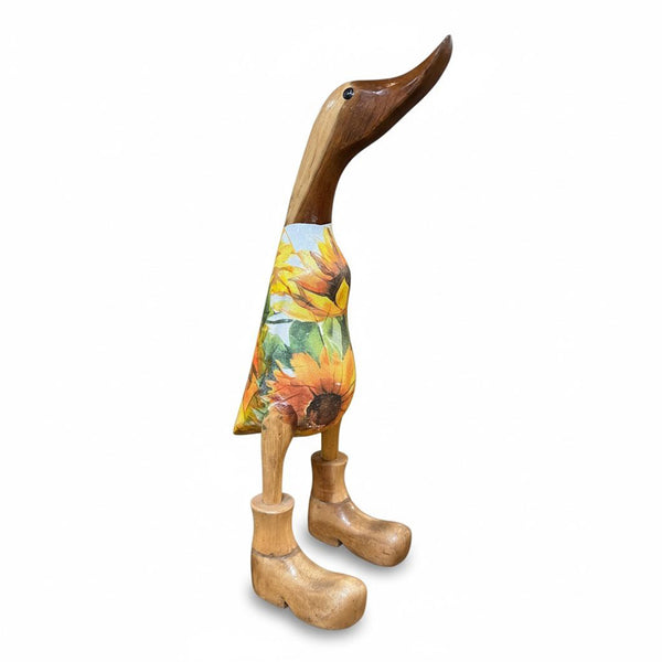 Detalle artesanal de pato en teca con botas rústicas