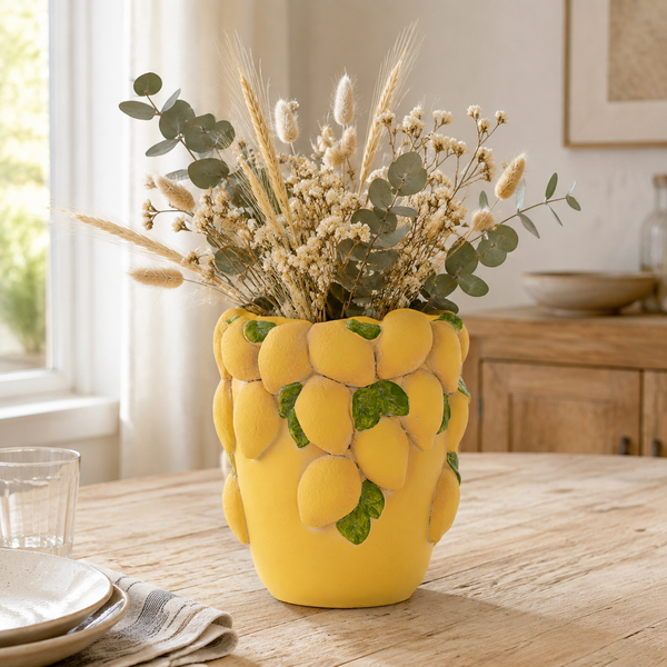 Jarrón amarillo de limones con flores secas y eucalipto como centro de mesa mediterráneo