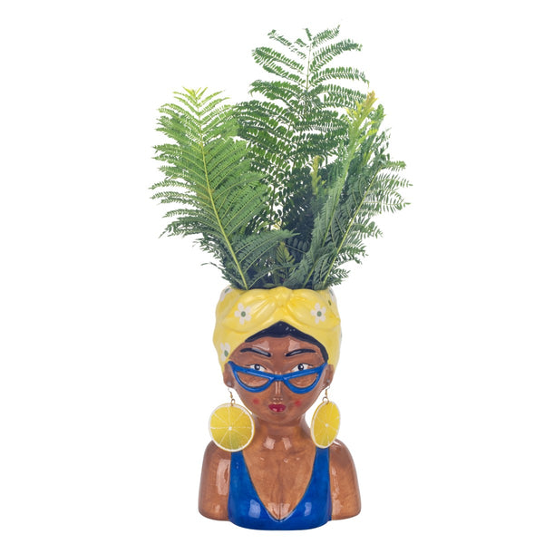 Jarrón decorativo con forma de mujer decorado con ramas verdes.