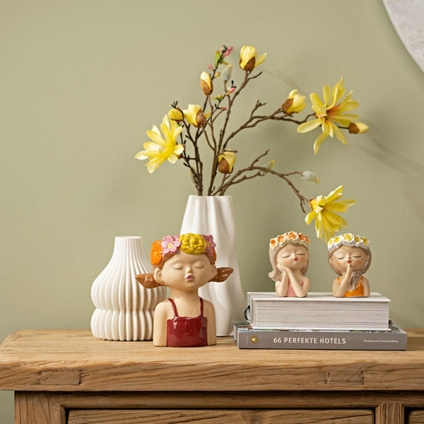 Decoración con jarrones de niñas de cerámica sobre mueble madera estilo Brocantia
