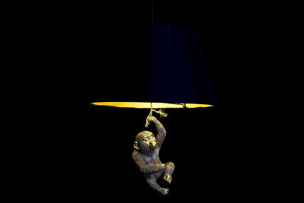 Lámpara encendida con interior dorado y figura colgante