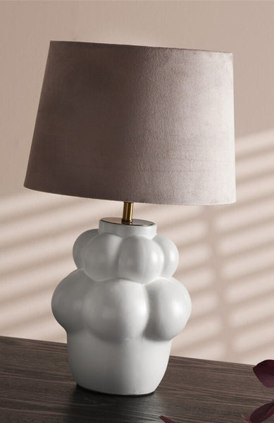 Candeeiro de mesa com formato branco e cúpula rosa.