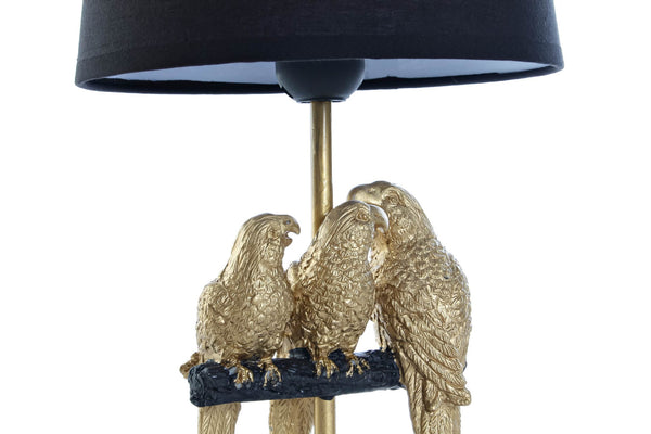 Detalle de loros dorados en lámpara exótica de mesa