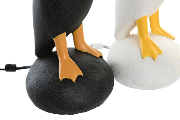 pies de lámparas decorativas de pato negro y blanco sobre base rocosa