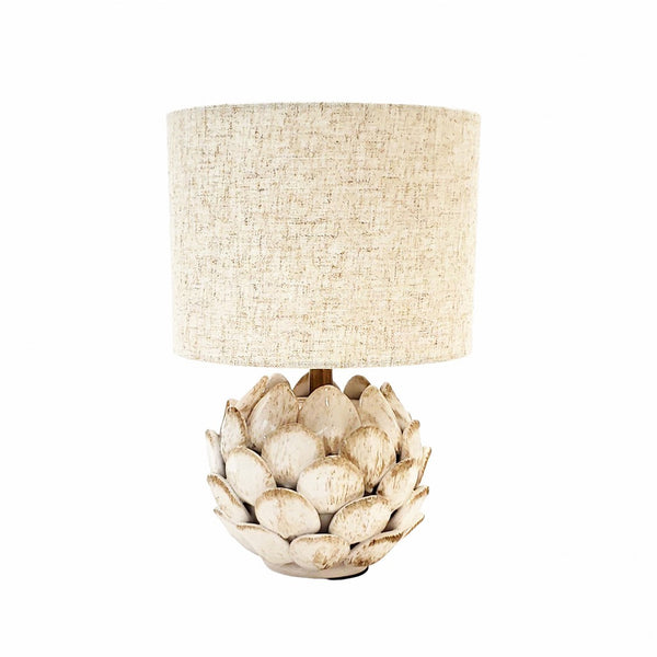 Lámpara de sobremesa Piña beige de cerámica con base decorativa en forma de piña y pantalla cilíndrica de tejido beige natural.