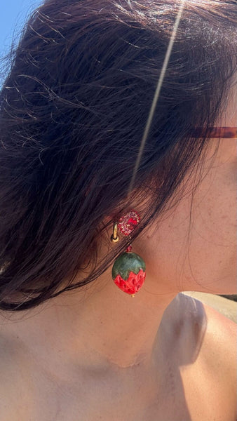Mujer luciendo pendientes de fresa artesanal siciliana con cerámica pintada a mano, joya creativa de Palermo
