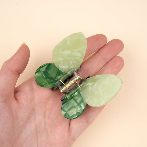 Pinza de mariposa verde sujeta en la mano mostrando su tamaño real