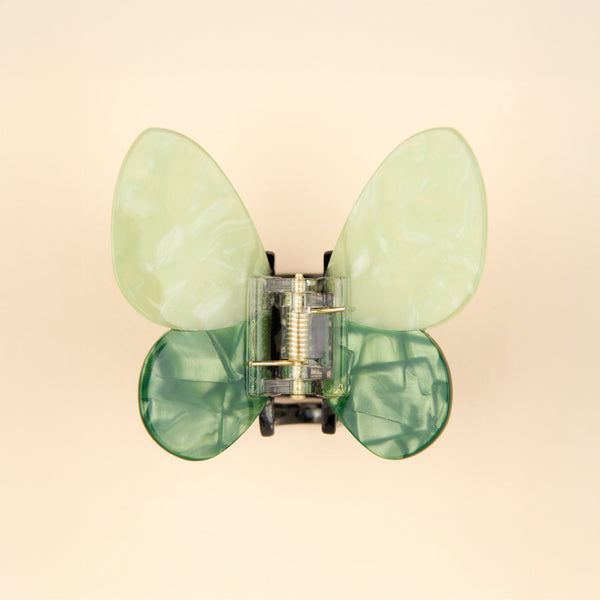 Pinza mariposa verde Coucou Suzette vista cenital sobre fondo beige